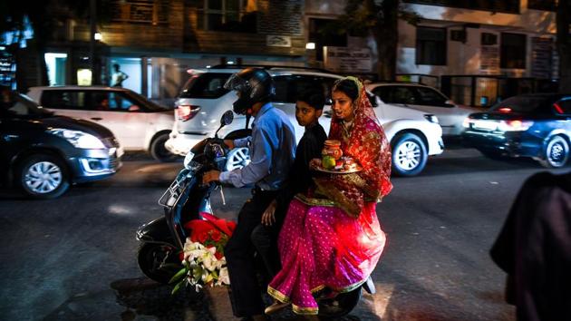 A Hindu family leaves on a scooter before performing rituals during the Karwa Chauth festival at a temple in New Delhi on October 27, 2018. (Chandan Khanna / AFP) A Hindu family leaves on a scooter before performing rituals during the Karwa Chauth festival at a temple in New Delhi on October 27, 2018. (Chandan Khanna / AFP)