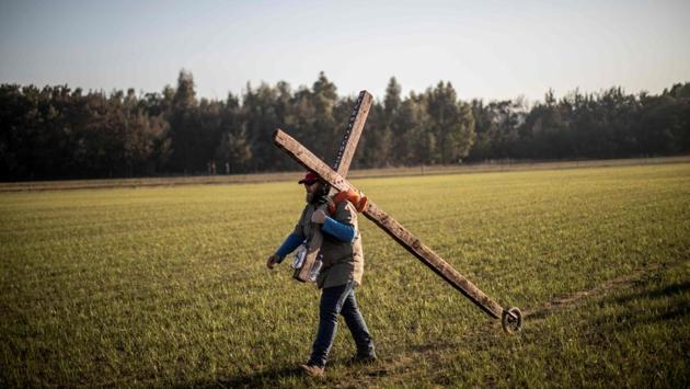 Bert Human - known as the ‘Silent Preacher’ - a follower of South African Christian revival evangelist Angus Buchan carries a cross while arriving at an informal airfield outside Pretoria, for the “It’s Time” prayer, an event poised to become the Southern Africa’s biggest ever prayer meeting. (Marco Longari / AFP)