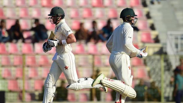 Zimbabwe cricketer Sean Williams (R) runs between the wickets with his teammate Peter Moor (L) during the first day of the first Test cricket match between Bangladesh and Zimbabwe in Sylhet on November 3, 2018.(AFP)