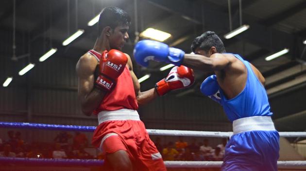 Rohan Patekar(red),Jimil Tomash(blue) in action during the national boxing championship in Pune,on Wednesday. (Shankar Narayan/HT PHOTO) 