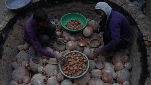 The dried diyas are then put in a brick-lined furnace. Ash is spread on the bottom of the furnace and diyas are then placed in it. The ash keeps them from overheating and ensures an even bake. The oven, covered with cow dung cakes is set on fire. An overnight simmer provides an even heat, gently baking the diyas. (Yogendra Kumar / HT Photo) The dried diyas are then put in a brick-lined furnace. Ash is spread on the bottom of the furnace and diyas are then placed in it. The ash keeps them from overheating and ensures an even bake. The oven, covered with cow dung cakes is set on fire. An overnight simmer provides an even heat, gently baking the diyas. (Yogendra Kumar / HT Photo)