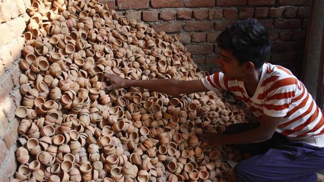 Once baked, the diyas are taken out and cleaned. Every step of production is organic, human. Very little technology or machines go into making these wonderful items. When it comes to storage, they don’t need special warehouses. An empty terrace corner is usually enough. (Yogendra Kumar / HT Photo) Once baked, the diyas are taken out and cleaned. Every step of production is organic, human. Very little technology or machines go into making these wonderful items. When it comes to storage, they don’t need special warehouses. An empty terrace corner is usually enough. (Yogendra Kumar / HT Photo)