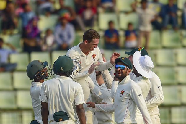 Zimbabwe's cricketers congratulate teammate Sean Williams (C) after the dismissal of Bangladesh cricketer Mehidy Hasan Miraz during the second day of the first Test cricket match between Bangladesh and Zimbabwe in Sylhet.(AFP)