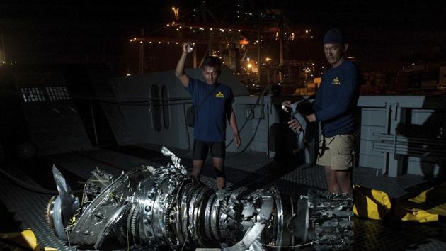 Navy divers inspect what is believed to be engine of the crashed Lion Air jet after it was retrieved from the sea floor, at Tanjung Priok Port in Jakarta, Indonesia.(AP)