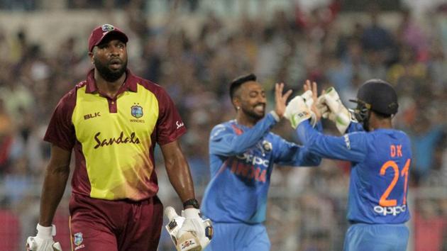 West Indies' Kieron Pollard, left, leaves the filed after being dismissed as India's Krunal Pandya, center, celebrates with teammate Dinesh Karthik during the first Twenty20 international cricket match between India and West Indies in Kolkata (AP)