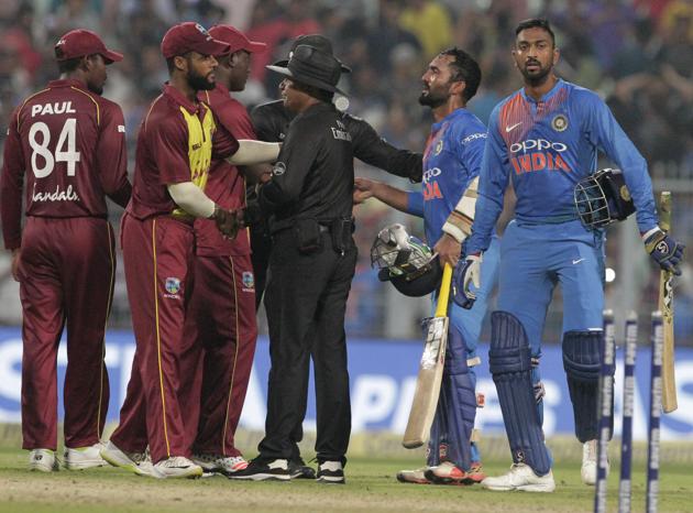 India's Krunal Pandya, right, and teammate Dinesh Karthik, second right, leave the field after their win over West Indies in the first Twenty20 international cricket match between India and West Indies in Kolkata. (AP)