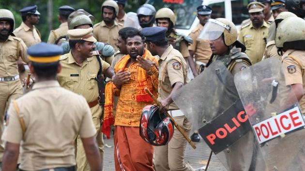 Police take a Hindu activist into custody as protesters rallied against a Supreme Court verdict revoking a ban on women's entry to a Sabarimala temple in Kerala. (AFP) Police take a Hindu activist into custody as protesters rallied against a Supreme Court verdict revoking a ban on women's entry to a Sabarimala temple in Kerala. (AFP)