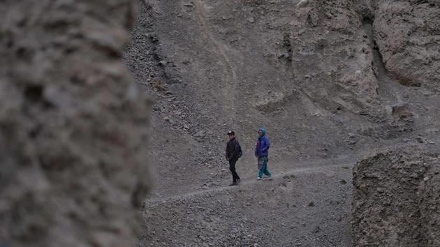 Haji Parveen (R), walks with her son from a mountain near her home in Shimshal village. Now her eldest, who is studying in Karachi, wants to become a porter like his father. “He talks about it every time he comes home and says he wants to be like his father. But we scold him because we hate the mountain: it’s useless, nothing at all.” (Aamir Qureshi / AFP) 