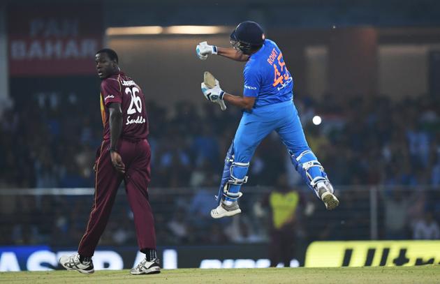 Indian cricket captain Rohit Sharma (R) celebrates after scoring a century (100 runs) as West Indies captain Carlos Brathwaite (L) looks on during the second T20 cricket match between India and West Indies at the Bharat Ratna Atal Bihari Vajpayee Ekana Cricket Stadium in Lucknow . (AFP)