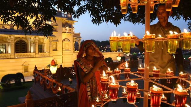 Workers light oil lamps during Diwali celebrations in Gandhinagar, some 30 kms from Ahmedabad. The festival of lights celebrates the return of Lord Rama to Ayodhya, and the triumph of good over evil. Hand made diyas, decorative lights and sky lanterns are some alternatives that people have opted for this year, in hope of a quieter, cleaner celebration for one of India’s biggest festivals. (Sam Panthaky / AFP) Workers light oil lamps during Diwali celebrations in Gandhinagar, some 30 kms from Ahmedabad. The festival of lights celebrates the return of Lord Rama to Ayodhya, and the triumph of good over evil. Hand made diyas, decorative lights and sky lanterns are some alternatives that people have opted for this year, in hope of a quieter, cleaner celebration for one of India’s biggest festivals. (Sam Panthaky / AFP)