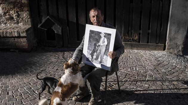 Truffle hunter Giovanni Monchiero poses with a picture of his grandfather Giovanni Monchiero. He is the dean of the unusual academy in Roddi and like his father, grandfather and great-grandfather, transforms “normal” dogs into expert seekers of the lucrative fungus. (Marco Bertorello / AFP) Truffle hunter Giovanni Monchiero poses with a picture of his grandfather Giovanni Monchiero. He is the dean of the unusual academy in Roddi and like his father, grandfather and great-grandfather, transforms “normal” dogs into expert seekers of the lucrative fungus. (Marco Bertorello / AFP)