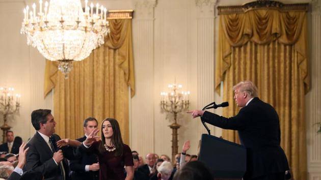 A White House staff member reaches for the microphone held by CNN's Jim Acosta as he questions US president Donald Trump during a news conference following midterm US congressional elections at the White House in Washington, US.(REUTERS)