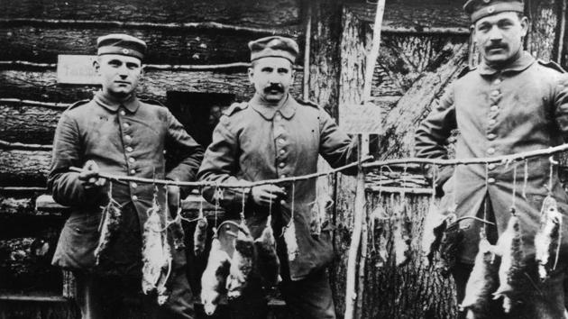 Three German soldiers display rats killed in their trench the previous night. (Faber / Getty Images) Three German soldiers display rats killed in their trench the previous night. (Faber / Getty Images)