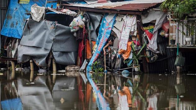 A man tries to fish something out of the water. It’s a familiar woe in the city where land fights frequently flare up between residents and a government seen to be in the pockets of powerful developers. (Kao Nguyen / AFP)