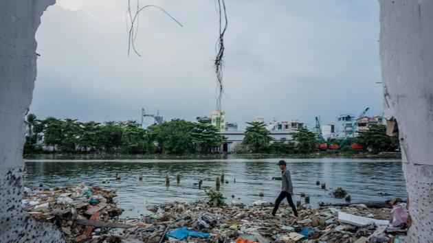 A man walks past a recently demolished house on the Te canal. Around 36,000 homes along the city’s canals have already been cleared, forcing residents to move to the outskirts or accept compensation that is often lower than soaring market rates. (Kao Nguyen / AFP)