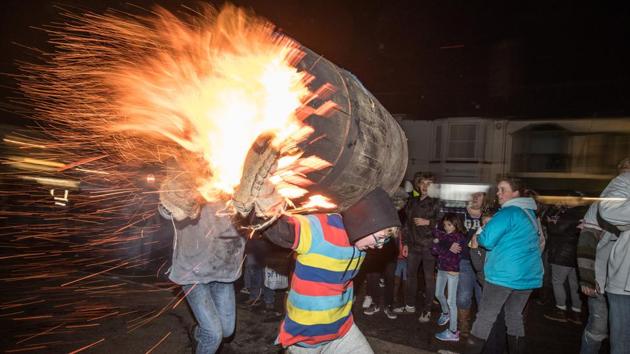 A participant runs with a burning barrel soaked in tar at the annual Ottery St Mary tar barrel festival in Devon, England. The tradition, which is over 400 years old, sees competitors (who must have been born in the town to take part) running with burning barrels on their backs through the village, until the heat becomes too unbearable or the barrel breaks down. (Matt Cardy / Getty Images) A participant runs with a burning barrel soaked in tar at the annual Ottery St Mary tar barrel festival in Devon, England. The tradition, which is over 400 years old, sees competitors (who must have been born in the town to take part) running with burning barrels on their backs through the village, until the heat becomes too unbearable or the barrel breaks down. (Matt Cardy / Getty Images)