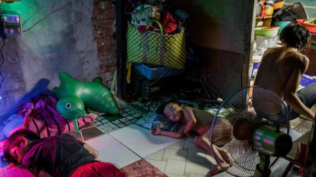 A family in a boarding house on the banks of the Xuyen Tam canal. Thanh runs a boarding house, mostly for rural migrant labourers, and sells lottery tickets from the slanted porch of her home pieced together with old wooden doors and metal sheets. (Kao Nguyen / AFP)