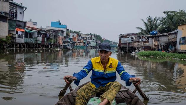 Le Ngoc Chau rowi a boat along the Xuyen Tam canal where he ekes out a living collecting scraps and ferrying passengers. The canals of Ho Chi Minh City have not always been so coveted. Under the French, they were the city’s main arteries used to move goods and people, but as roads modernised and as the population boomed, they became places to illegally settle. (Kao Nguyen / AFP)