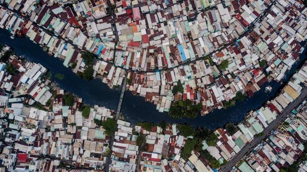 On the banks of Ho Chi Minh City’s Xuyen Tam canal the houses come in many forms. Short or tall, pieced together from scraps of wood, or metal or plastic. Some tilt precariously over the polluted water’s edge. (Kao Nguyen / AFP)