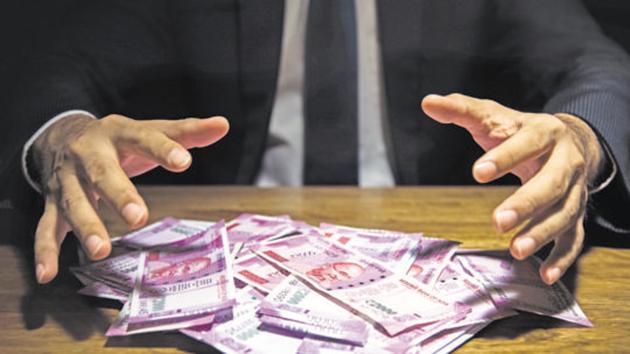 Businessman taking pile of money, Indian Rupee banknotes, on his desk in a dark office - corruption concept(Getty Images/iStockphoto) Businessman taking pile of money, Indian Rupee banknotes, on his desk in a dark office - corruption concept(Getty Images/iStockphoto)