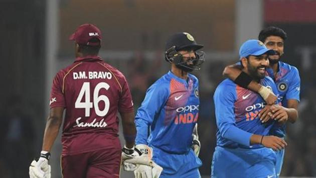 West Indies cricketer Darren Bravo (L) walks to the pavillon as Indian cricket captain Rohit Sharma (2R) celebrates his wicket during the second T20 cricket match between India and West Indies.(AFP)