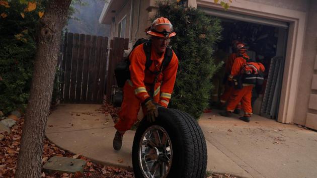 An inmate firefighter removes a wheel from a burning home. People in Paradise, like so many in California, have become accustomed to wildfires, and many said they were well prepared. They kept their gutters clean, some kept pumps in their swimming pools and had fire hoses. But the ferocity and speed of this blaze overwhelmed those preparations. (Stephen Lam / REUTERS) An inmate firefighter removes a wheel from a burning home. People in Paradise, like so many in California, have become accustomed to wildfires, and many said they were well prepared. They kept their gutters clean, some kept pumps in their swimming pools and had fire hoses. But the ferocity and speed of this blaze overwhelmed those preparations. (Stephen Lam / REUTERS)