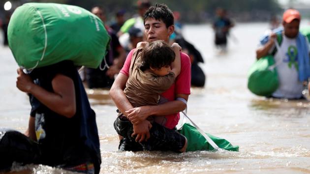 A young man holds the child looking exhausted and others clutching all their worldly possessions. According to Mills, this image shows that how desperate these people are that they are willing to cross rivers with strong currents, to lose any belongings they had, to struggle through the water with their children. He added, that we are lucky, that we have access to proper shoes, equipment, water and food, whereas the migrants don’t. (Leah Millis / REUTERS) 