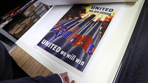 Brian Sylvester, director of the Rochester Public Library, examines original war posters at the library's archive in Rochester, New Hampshire.(AP) Brian Sylvester, director of the Rochester Public Library, examines original war posters at the library's archive in Rochester, New Hampshire.(AP)