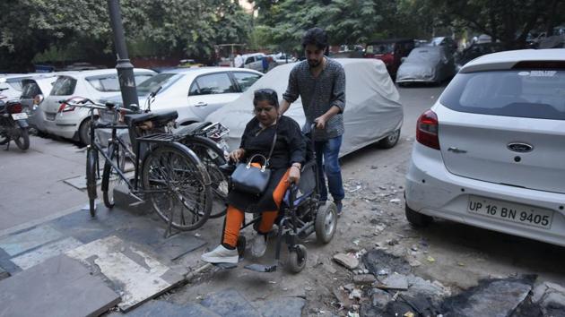 A differently- abled person commutes via her wheel chair, at Community Center Market, New Friends Colony, in New Delhi.(Burhaan Kinu/HT PHOTO)