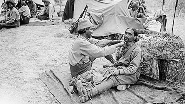 An Indian barber at work in the Indian Cavalry Camp, possibly the 9th Hodson’s Horse, near Querrieu, France, July 29, 1916. Several makeshift tents can be seen in the background.  (Imperial War Museums) 