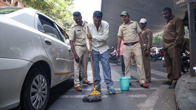 A violator mopping up his spit during a drive at Mhasoba gate chowk, Shivajinagar on Monday. (SANKET WANKHADE/HT PHOTO) 