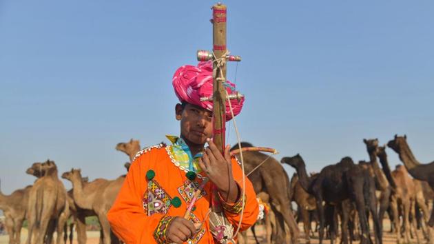A Rajasthani youth plays a "Ravanahatha" (traditional stringed instrument) at the Pushkar Camel Fair in Pushkar, in Rajasthan. Thousands of livestock traders from the region come to the traditional camel fair where livestock, mainly camels, are traded. The Pushkar Fair official programme events and fairground this year will run from November 16 to 23. (Shaukat Ahmed / AFP) A Rajasthani youth plays a "Ravanahatha" (traditional stringed instrument) at the Pushkar Camel Fair in Pushkar, in Rajasthan. Thousands of livestock traders from the region come to the traditional camel fair where livestock, mainly camels, are traded. The Pushkar Fair official programme events and fairground this year will run from November 16 to 23. (Shaukat Ahmed / AFP)