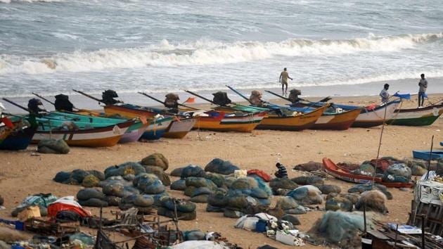 Fishermen stand along a beach beside fishing boats on the coast of the Bay of Bengal, in Chennai on November 12.(AFP Photo) Fishermen stand along a beach beside fishing boats on the coast of the Bay of Bengal, in Chennai on November 12.(AFP Photo)