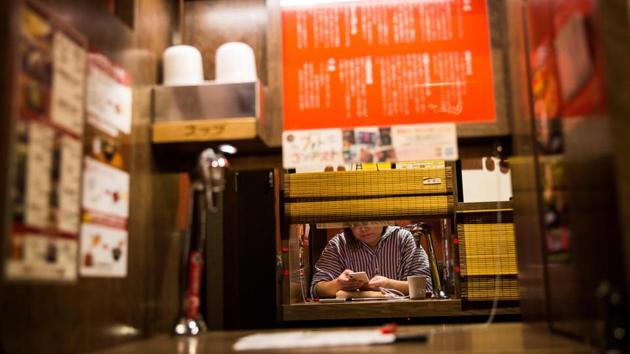 Restaurants are also cashing in. At the “Ichiran” ramen noodle chain, it is possible to enjoy a meal with barely any human interaction whatsoever. Customers order from vending machines and then sit in a partitioned booth to slurp down their noodles, unlike the experience at many ramen joints, where orders are shouted by teams of chefs behind greasy counters. (Behrouz Mehri / AFP) Restaurants are also cashing in. At the “Ichiran” ramen noodle chain, it is possible to enjoy a meal with barely any human interaction whatsoever. Customers order from vending machines and then sit in a partitioned booth to slurp down their noodles, unlike the experience at many ramen joints, where orders are shouted by teams of chefs behind greasy counters. (Behrouz Mehri / AFP)