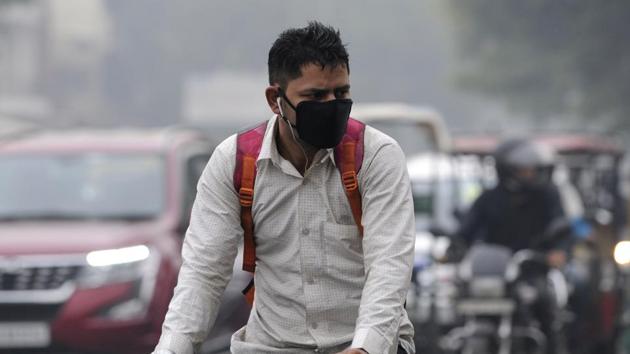 A man wears a pollution mask amid heavy smog, in Noida, on Tuesday, November 13,2018.(HT Photo)
