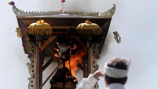 A Balinese man watches the cremation of Ida Anak Agung Ayu Oka Pemecutan, a member of the Denpasar royal family, during a Hindu Ngaben, or cremation ceremony, in Denpasar, Bali on November 14, 2018. (Johannes P. Christo / REUTERS) A Balinese man watches the cremation of Ida Anak Agung Ayu Oka Pemecutan, a member of the Denpasar royal family, during a Hindu Ngaben, or cremation ceremony, in Denpasar, Bali on November 14, 2018. (Johannes P. Christo / REUTERS)