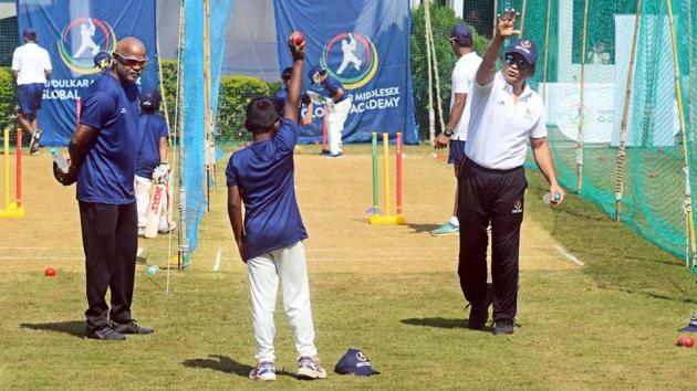Sachin Tendulkar (right) and Vinod Kambli (left) train children at Tendulkar Middlesex global academy at the Bishop’s school in Camp on Thursday. (SHANKAR NARAYAN/HT PHOTO)