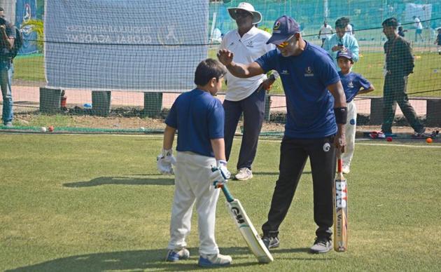 Vinod Kambli shares a light moment with a child at Tendulkar Middlesex global academy at the Bishop’s school in Camp on Thursday. (SHANKAR NARAYAN/HT PHOTO)