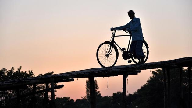 A man walks back home after work over a bamboo bridge in Barpeta, Assam. (David Talukdar / AFP) A man walks back home after work over a bamboo bridge in Barpeta, Assam. (David Talukdar / AFP)