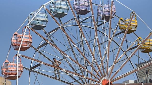 A worker runs a maintenance drill on a Ferris wheel at Andheri in Mumbai, Maharashtra. (Satyabrata Tripathy / HT Photo) A worker runs a maintenance drill on a Ferris wheel at Andheri in Mumbai, Maharashtra. (Satyabrata Tripathy / HT Photo)