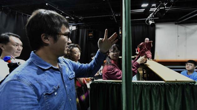 Students during the practice session. Puppeteers manoeuvre small glove dolls on ornate wooden stages to present historical and martial arts stories accompanied by live folk music. Chen said he values the traditional puppetry because it is characterised by subtle movements, with the puppeteer taking on all roles, from a young woman to an old man. (Sam Yeh / AFP) Students during the practice session. Puppeteers manoeuvre small glove dolls on ornate wooden stages to present historical and martial arts stories accompanied by live folk music. Chen said he values the traditional puppetry because it is characterised by subtle movements, with the puppeteer taking on all roles, from a young woman to an old man. (Sam Yeh / AFP)