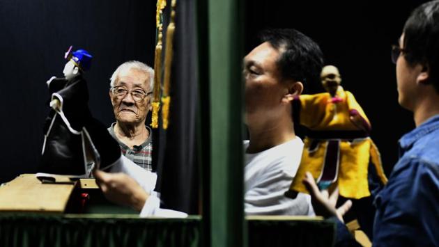 Chen stands next to a puppet show being performed by his students. Puppet master vows to continue performing and teaching as long as he still has the strength. “I haven’t completed passing on the art so I can’t retire,” he said. (Sam Yeh / AFP) Chen stands next to a puppet show being performed by his students. Puppet master vows to continue performing and teaching as long as he still has the strength. “I haven’t completed passing on the art so I can’t retire,” he said. (Sam Yeh / AFP)