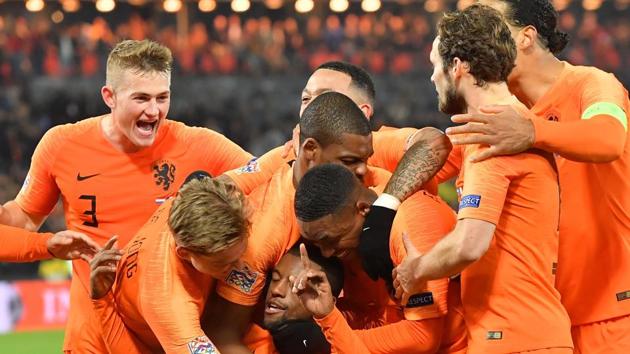 Netherlands' midfielder Georginio Wijnaldum (bottom) celebrates with team mates after scoring a goal.(AFP)