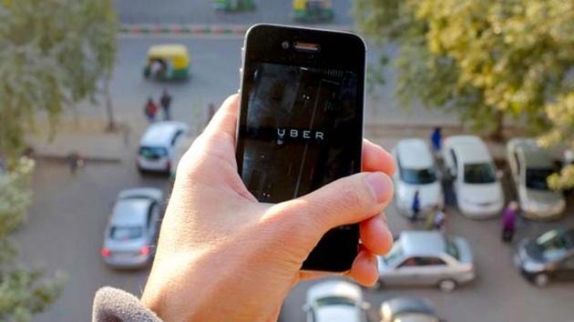 The Uber smartphone app, used to book taxis using its service, is pictured over a parking lot.(AFP File Photo)