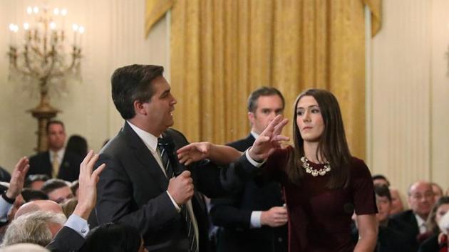 A White House intern reaches for and tries to take away the microphone held by CNN correspondent Jim Acosta as he questions US President Donald Trump during a news conference at the White House in Washington on November 7.(REUTERS)