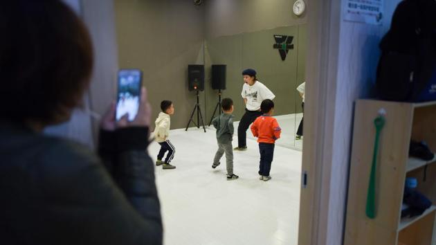 Inside a dance studio in central Beijing, a group of kids bopped up and down to an American hip-hop beat as they mimicked their teacher, a young woman in a dark blue beret and loose clothing. Some practised in earnest -- bending their arms just so -- while others giggled, treating the class more like play. (Wang Zhao / AFP)