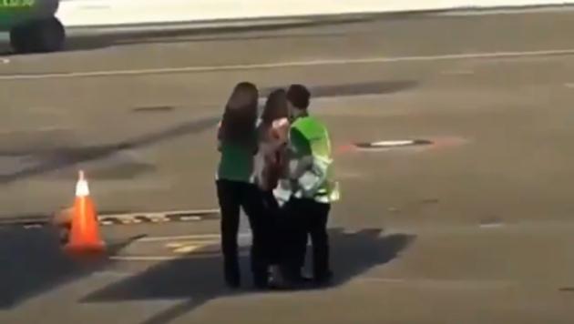 The video shows the woman trying to break free and chase after her flight.(Twitter/@goenrock)