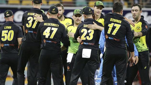 Australia players celebrate after winning the first T20 International cricket match against India in Brisbane.(AP)