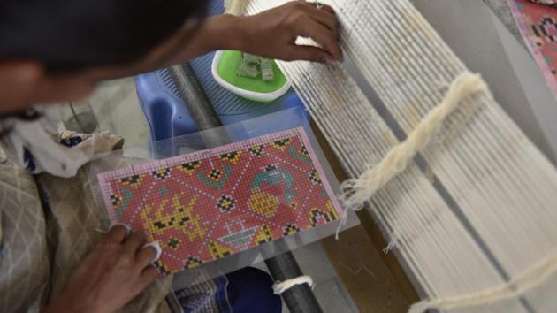 A weaver works on a sari at Patola House, a double storied space that acts as Rohit --a national award winning Patola weaver from Patan-- and his family’s workshop and an exhibition area. According to one story of its origins, Kumarpal, a ruler of Patan, was so fond of the Patola weave that he brought 700 families of weavers from Maharashtra, where this weave had originated, to Patan. (Sanchit Khanna / HT Photo)
