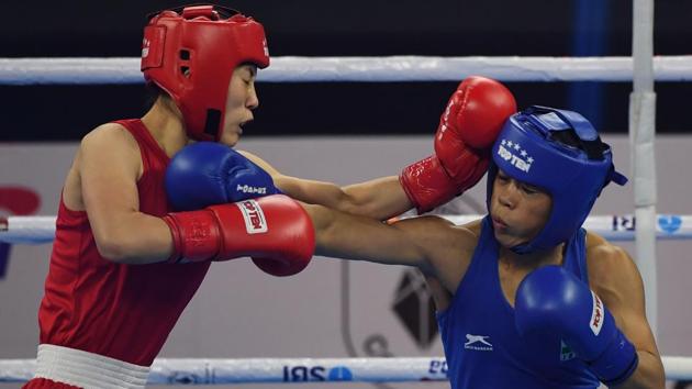 Mary Kom of India (in blue) and Kim Hyang Mi of North Korea (in red) compete during their 45-48 kg category semi-final fight.(AFP)